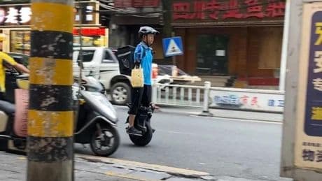 "Perseverar trae recompensas": el repartidor chino de comida sin brazos que usa el móvil con los labios y escribe con los pies