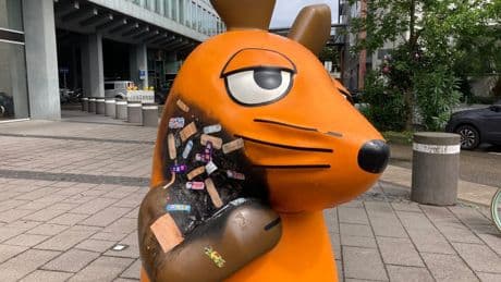 Angebrannte Maus-Figur wird mit Pflastern versorgt