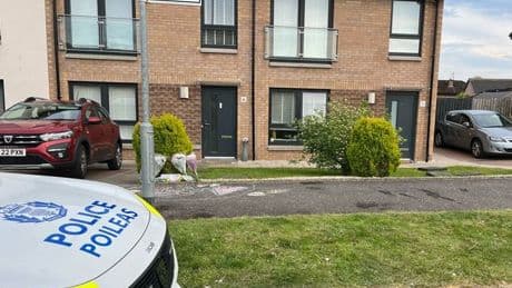 Floral tributes at Glasgow home after death of OAP as police remain at scene