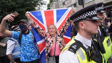 Rival groups face off outside migrant hotel - as asylum seekers 'blow kisses' at protesters