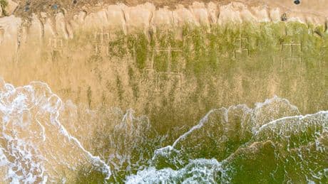 Early Hawaiian petroglyphs on a beach are visible again with changing tides and shifting sands