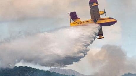 Un bombero explica cómo actuar ante un avión que descarga agua en un incendio