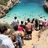 The 'secret' Spanish paradise beach ruined by influencers: Videos show piles of rubbish and tourists queuing to reach sand at Majorca beauty spot lauded by Instagrammers