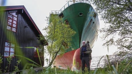A cargo ship that ran aground in Norway, narrowly missing a house, is being towed to a nearby harbor