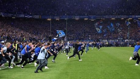 Huge pitch invasion sees 25 fans rushed to hospital and one suffer 'life-threatening injuries'