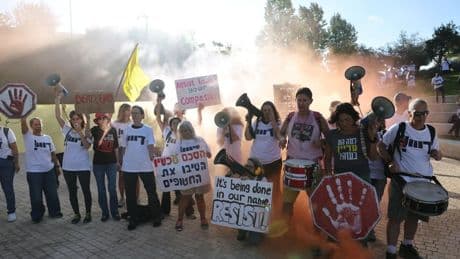 Manifestantes israelíes suben al tejado de la Biblioteca Nacional y protestan contra Netanyahu quemando neumáticos