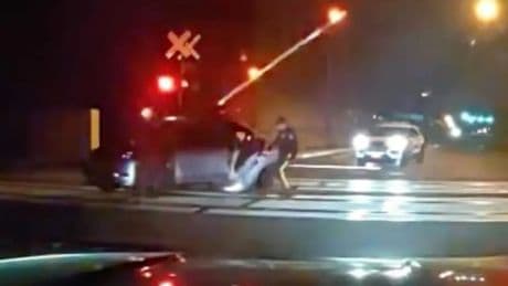 Shock vid shows hero cops pull driver from car just SECONDS before its obliterated by speeding train on level crossing