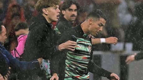 VIDEO Man rijdt met rolstoel tegen benen Cristiano Ronaldo, veldbestormer valt hem tijdens warming-up in München lastig