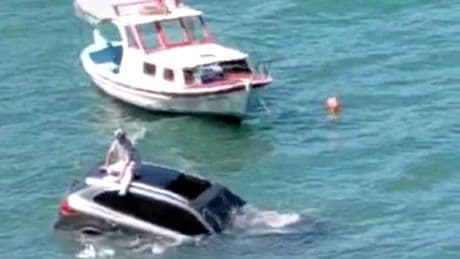 Denize uçan otomobilin üstünde oturdu yardım bekledi