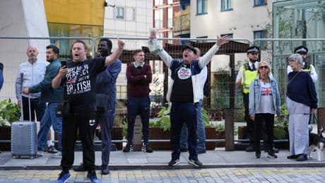Police officer punched as masked anti-asylum protesters march through Canary Wharf shopping centre