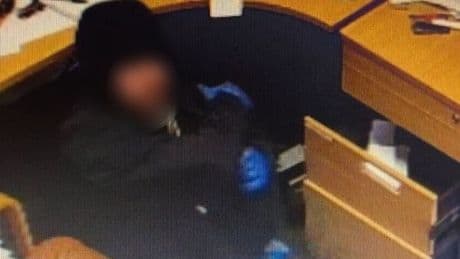 Crook wearing blue forensic gloves raids Scots restaurant offices for cash