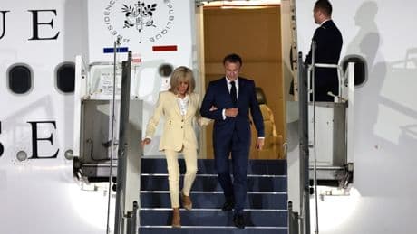 Moment Macron tries to laugh off ‘disturbing’ Brigitte slap in mocking wave as he steps off plane arm in arm with wife