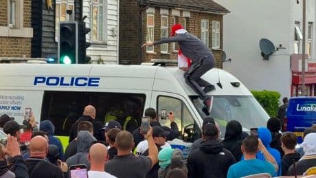 Riot police smash through blockade as protesters clash over migrant hotel