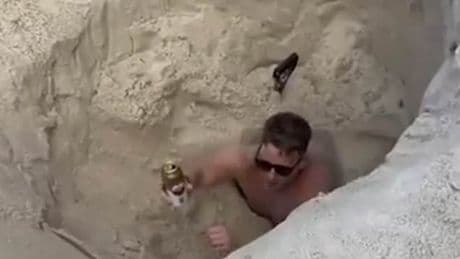 British tourist got stuck in hole he dug on beach then had very British reaction