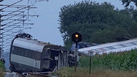 Woman dead and dozens injured after train carrying 100 passengers collides with slurry tanker in Denmark