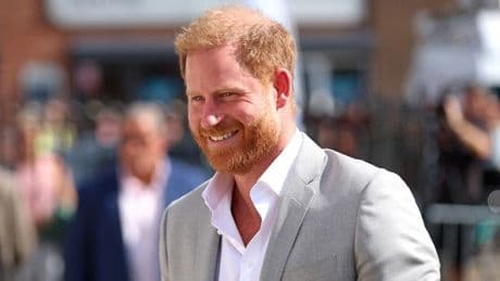 Prince Harry grins on charity trip as diary battle with William rages on