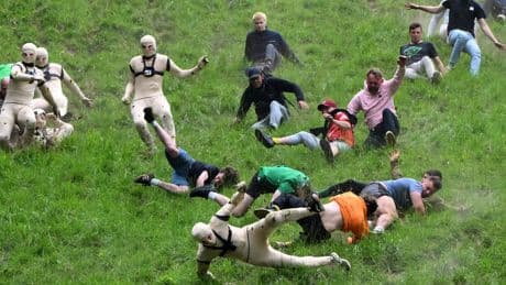 AP PHOTOS: Runners trip, stumble and roll their way to victory in annual downhill cheese chase