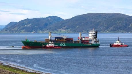 A cargo ship that ran aground in Norway, narrowly missing a house, is being towed to a nearby harbor