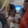 Air rage woman is overpowered by male passengers and tied up in mid-air after demanding business class upgrade while grabbing her breasts yelling 'I'm in pain in my butt and my t*ts!