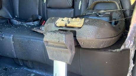 Shocking image of family car firebombed in gar war shows charred baby seat