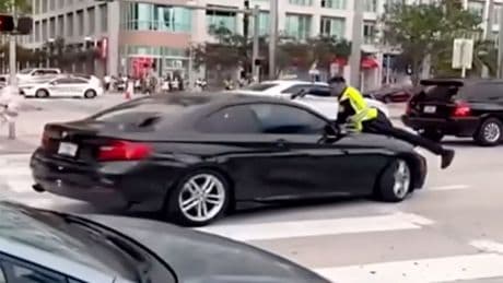 Shocking video shows cop on the hood of a moving car before shooting suspect