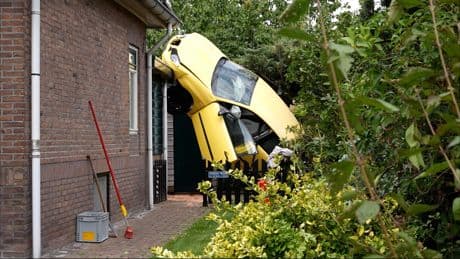 Bizar: auto belandt verticaal tegen gebouw aan na ongeluk in Hengelo