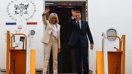 Emmanuel Macron and wife Brigitte all smiles and hand holding as they board plane after shove video