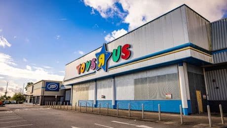 Inside abandoned Toys R Us shop with eerie empty shelves and checkouts left to rot
