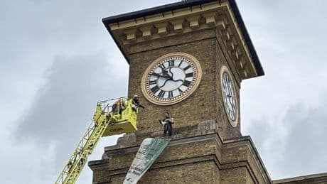 Video: Moment activist clutching dog scales London station in Iran protest