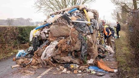 Man and company charged after 27 TONNE mountain of rotting rubbish dumped in road bigger than two double-decker buses