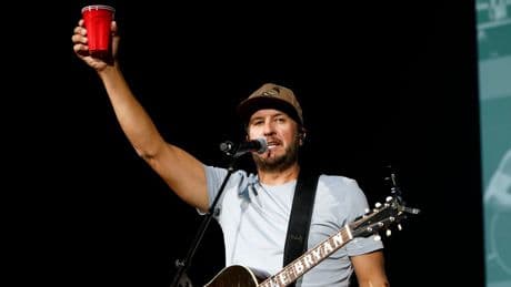 Luke Bryan reacts after being hit in the face by object during concert