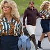 Emily Atack sports voluminous 80's hair and flashes her pins in a navy pencil skirt as she joins Danny Dyer on the set of Rivals series two