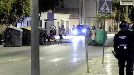 Anti-migrant groups throw bottles at riot police in Spain during unrest