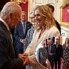 Something to smile about, Sir David? Becks jokes with King Charles at star-studded reception with Meryl Streep and Kate Winslet just two days before his knighthood is made official