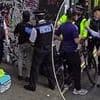Moment 'Deliveroo rider' is held in police crackdown on migrants working illegally after fast food delivery bikes were found outside Home Office-funded hotel