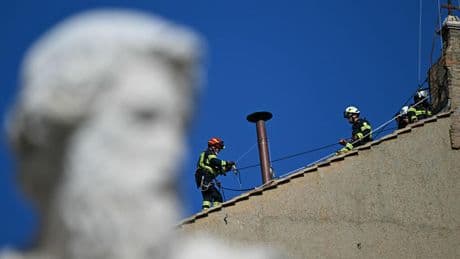Vatican firefighters install the Sistine Chapel's chimney in preparation for papal conclave