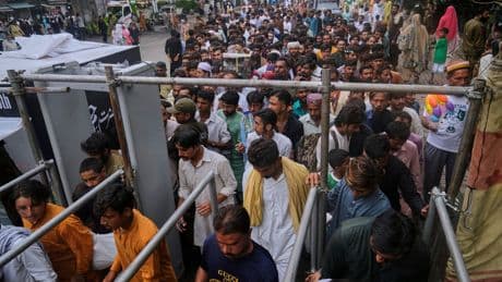Photos of Pakistan honoring a Sufi saint with drumming, dancing, and bright lights