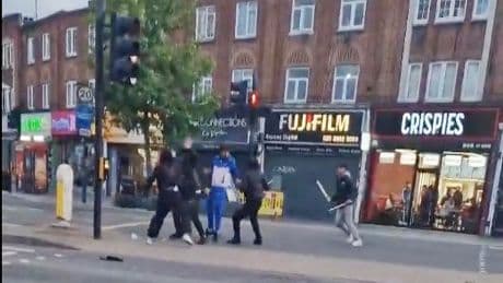 Moment thugs use huge STICKS & baseball bats as weapons as brawl erupts on busy high street in broad daylight