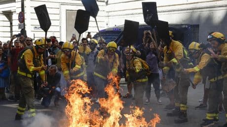 Los forestales 'queman' la calle Alcalá para protestar ante Hacienda: incendio controlado al grito de "el fuego nos mata"