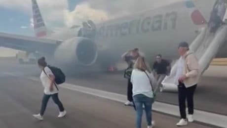 American Airlines passengers flee on emergency slide after Boeing plane wheel catches fire