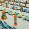 Op het Italiaanse strand blijven de ligbedjes leeg. Over de oorzaak wordt volop gebekvecht