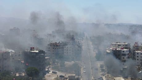 Homes still burning after mass pillaging and 30,000 trapped in besieged city - as Syria's fragile ceasefire holds