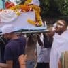 KIJK. Met de pleisters nog op zijn gezicht: enige overlever vliegramp India draagt kist van broer