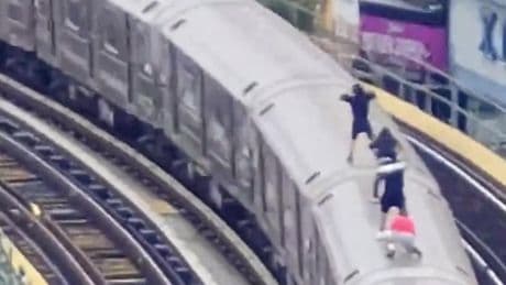 Young subway surfers caught travelling on top of moving train by police drone team