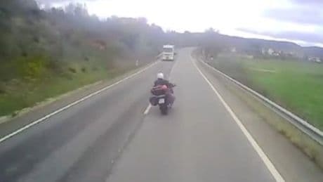 Arriesgado y peligroso adelantamiento de un motociclista a un camión: ¿Qué multa le podría imponer la DGT?