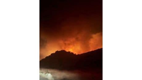 Firefighters battle a fast-moving blaze along a highway north of Los Angeles