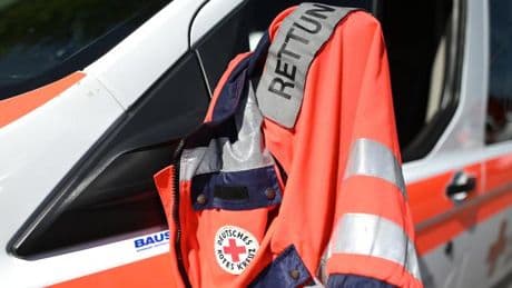 Angehöriger eines Patienten tritt Sanitäter die Treppe hinunter