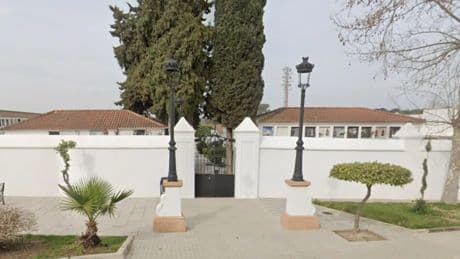 Un operario deja un féretro en un contenedor de basura cerca del cementerio de Castilblanco de los Arroyos