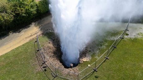 Residential street flooded as burst main shoots 100ft jet of water into the air