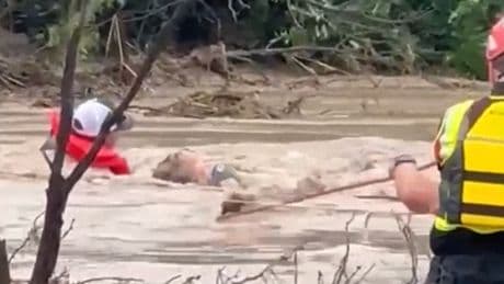 Residents cling to rope as Texas floodwater surges around them